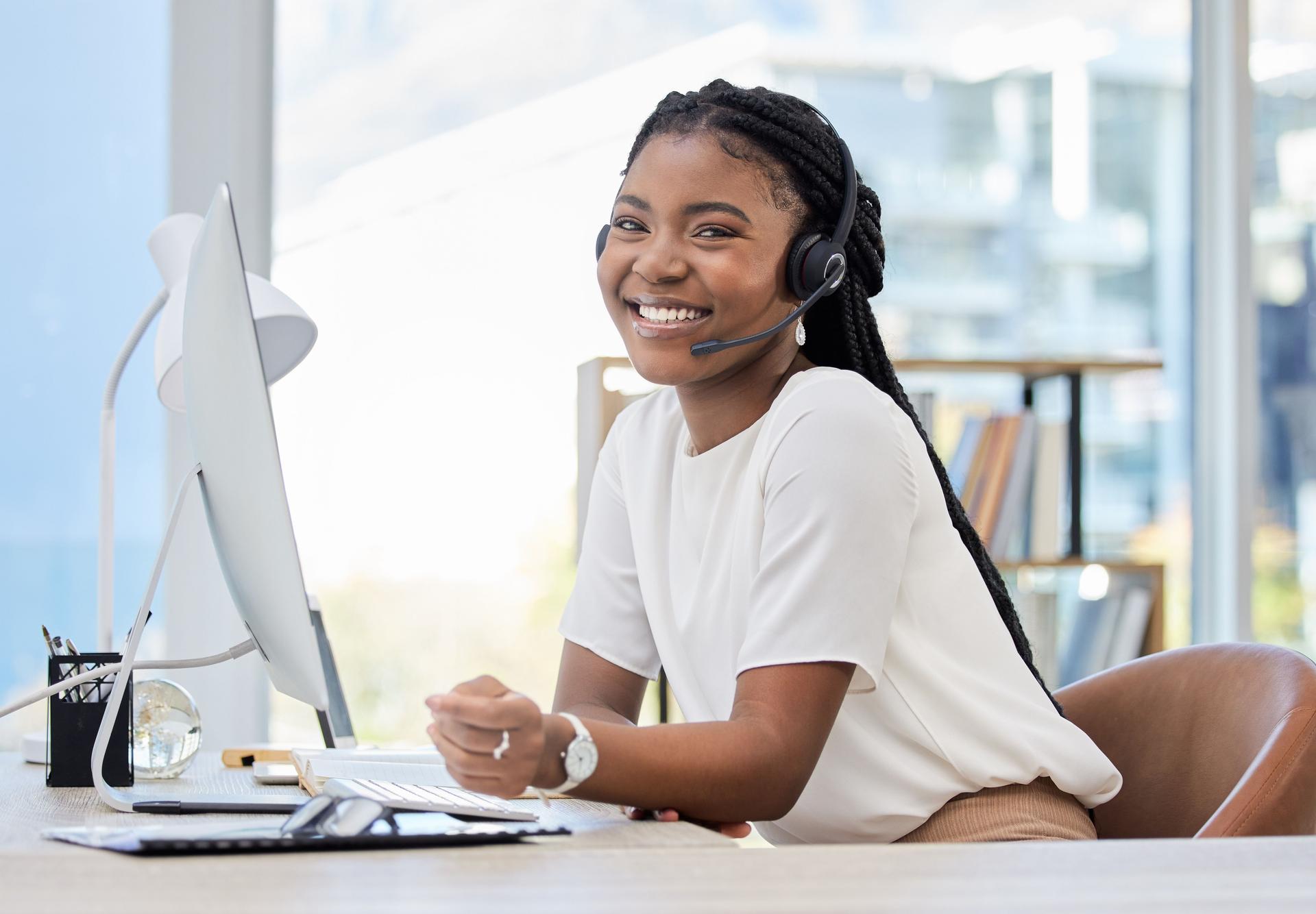 Shot of a young female call center agent using a computer at work