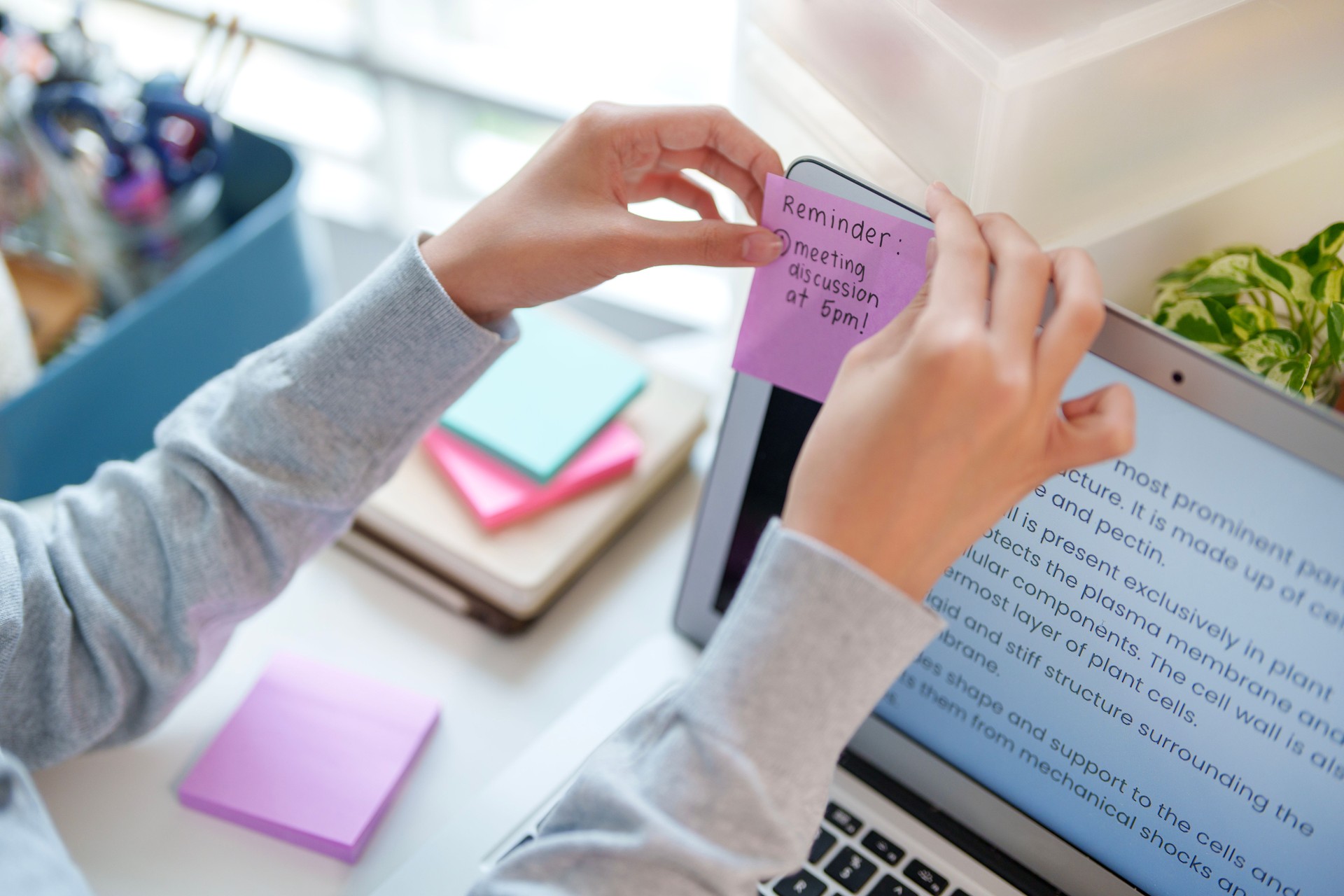 Cropped image of a teenage Asian girl is seen using adhesive notes while studying for an exam.